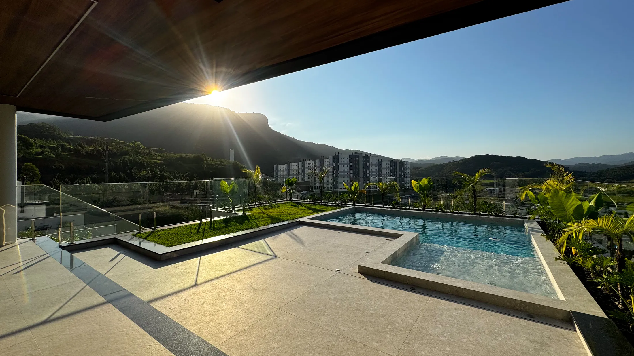 Piscina com hidromassagem da Casa Van Gogh e vista para a Pedra Branca ao entardecer, em Palhoça