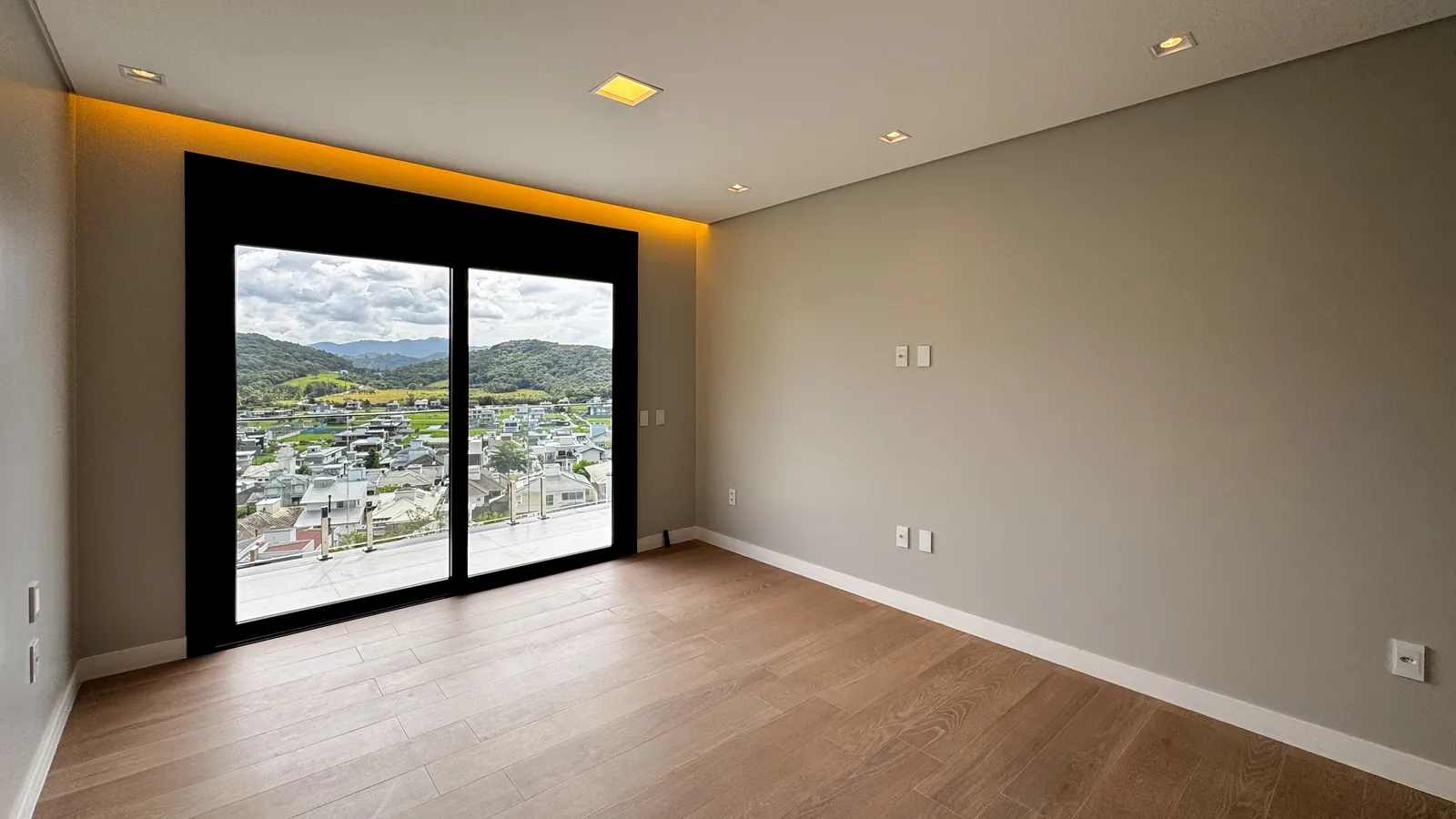 Suíte da Casa Van Gogh com piso de madeira e vista para a cidade