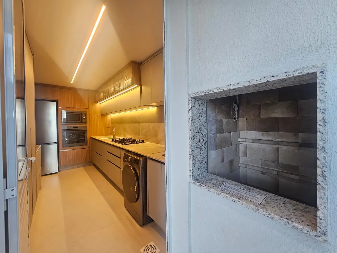 Cozinha integrada com churrasqueira e revestimento em pedra